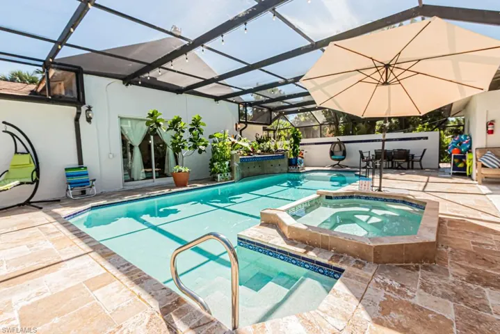 View of pool featuring glass enclosure, a patio area, and a sunroom