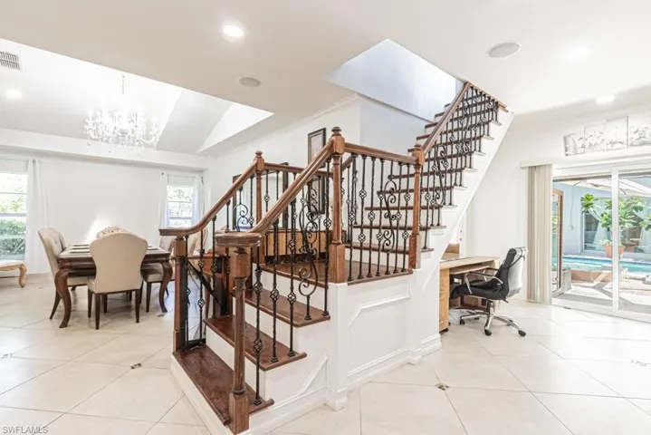 Stairs featuring healthy amount of natural light, tile patterned flooring, a chandelier, recessed lighting, and crown molding