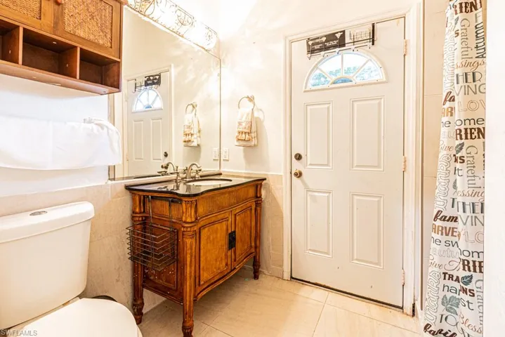 Guest House Bathroom featuring tile walls, vanity, a wainscoted wall, and a shower with curtain