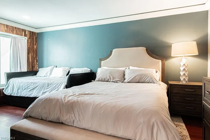 Bedroom featuring wood finished floors and ornamental molding