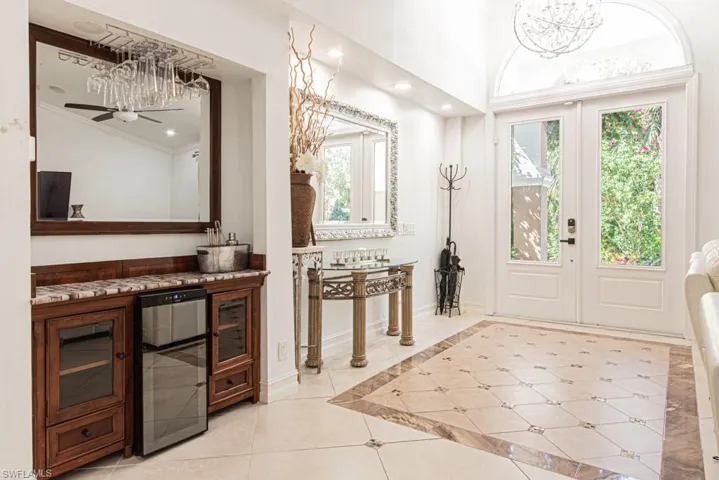 Bar area with light tile patterned floors, plenty of natural light, inlaid floor details, beverage cooler, and recessed lighting