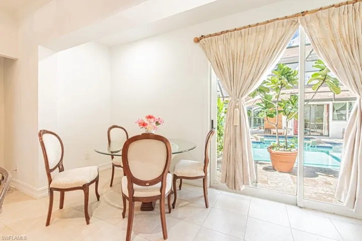Guest House Dining room with light tile patterned floors and baseboards