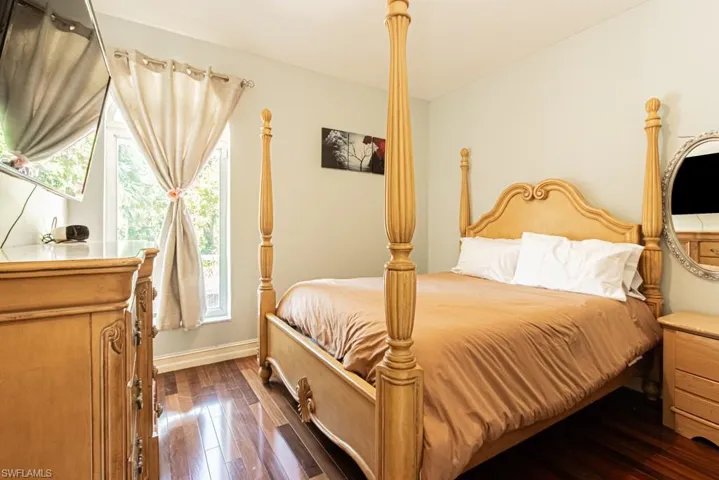 Bedroom featuring dark wood-style flooring and baseboards