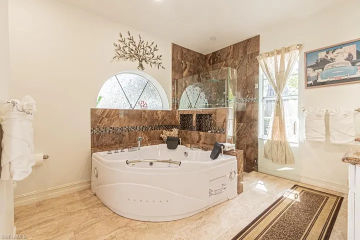 Full bathroom featuring walk in shower and a tub with jets