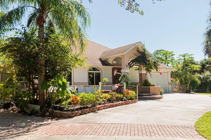 View of front of home featuring roof with shingles, driveway, a garage, and stucco siding