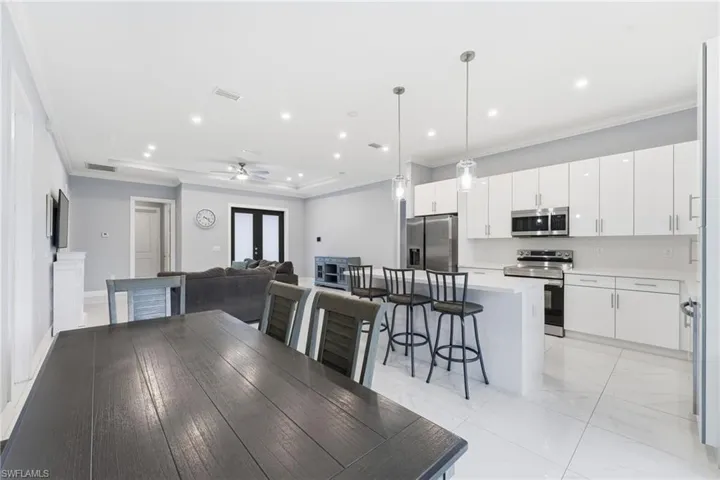 Dining area with crown molding, a ceiling fan, a tray ceiling, and recessed lighting