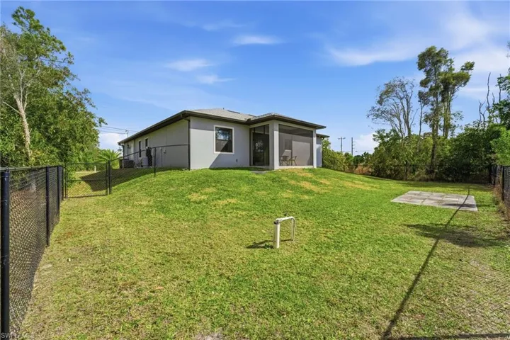 Rear view of house with a fenced backyard, stucco siding, and a sunroom