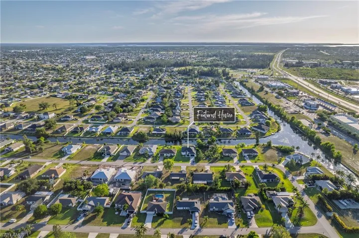 Aerial view of property and surrounding area with nearby suburban area