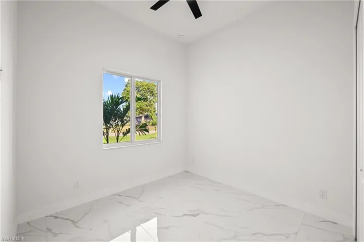 Unfurnished room with baseboards, ceiling fan, and marble finish floors