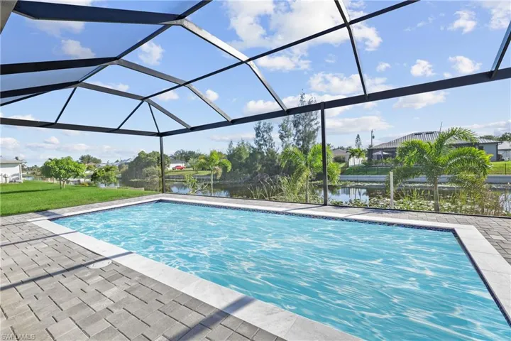 Swimming pool featuring a water view, a patio area, and a lanai