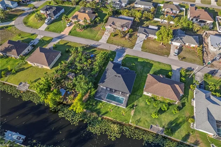 Aerial view of property and surrounding area with nearby suburban area