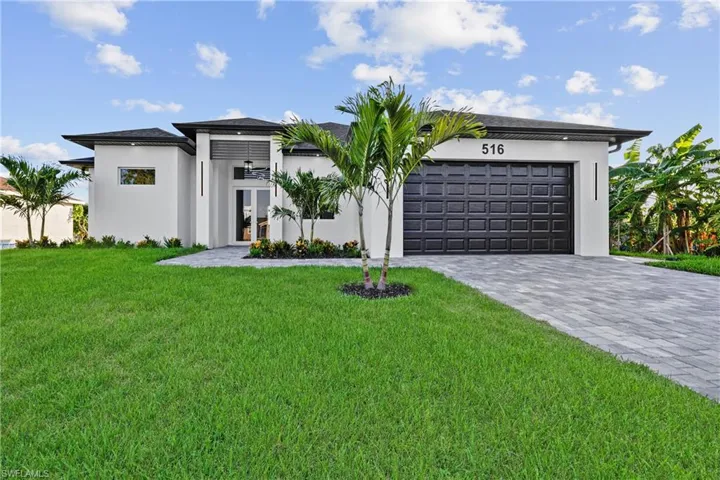 View of front of property with french doors, an attached garage, decorative driveway, and stucco siding