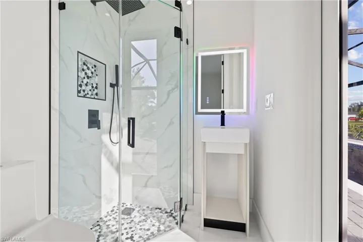 Full bathroom featuring a marble finish shower and healthy amount of natural light