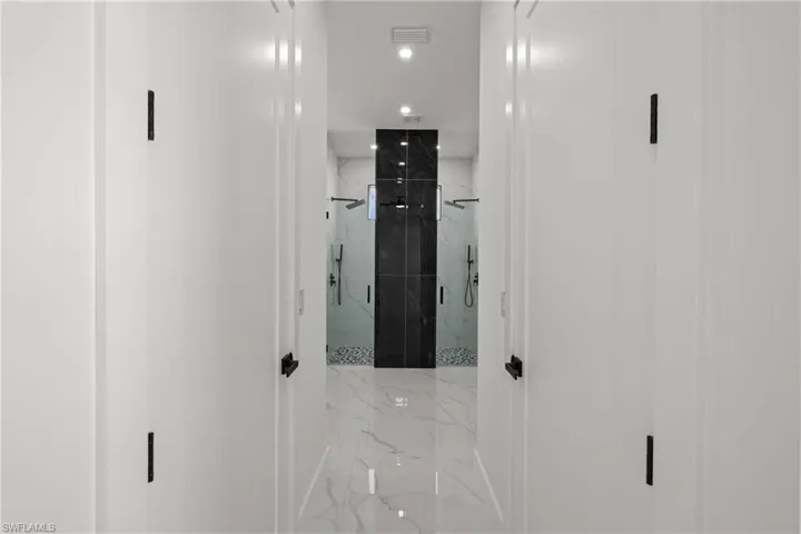 Hallway featuring marble finish floors and recessed lighting
