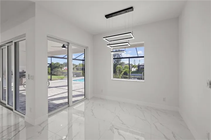 Spare room with baseboards, marble finish floors, and healthy amount of natural light