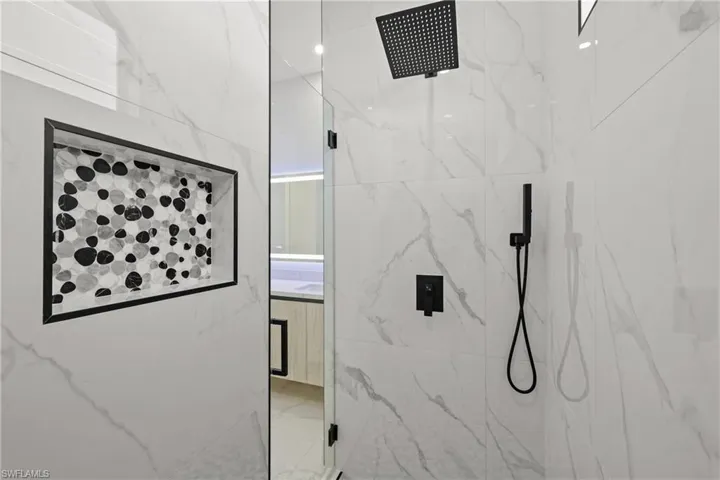 Full bathroom featuring a marble finish shower, marble finish flooring, and vanity