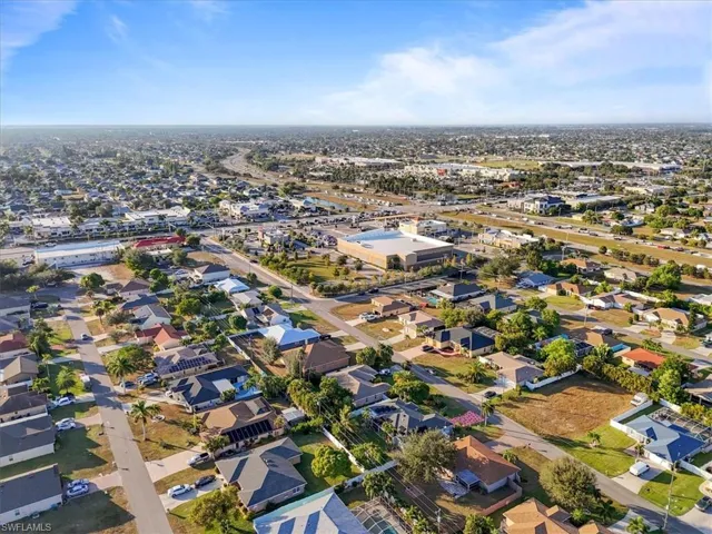Aerial view of property and surrounding area featuring nearby suburban area