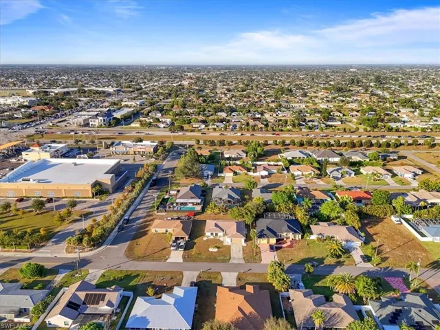 Aerial view of property and surrounding area with nearby suburban area