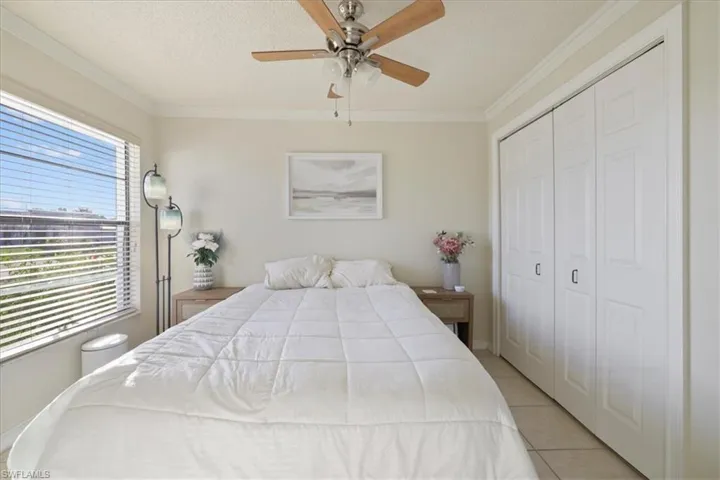 2nd Bedroom featuring crown molding, a closet, a textured ceiling, a ceiling fan, and light tile patterned floors