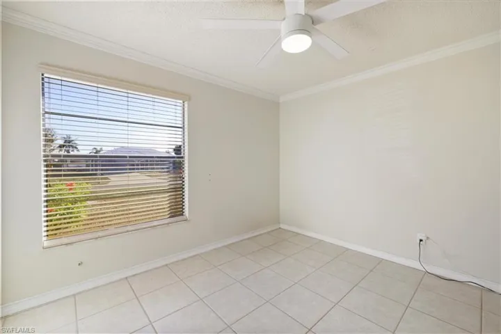 3rd bedroom featuring crown molding, a textured ceiling, ceiling fan, and light tile patterned floors