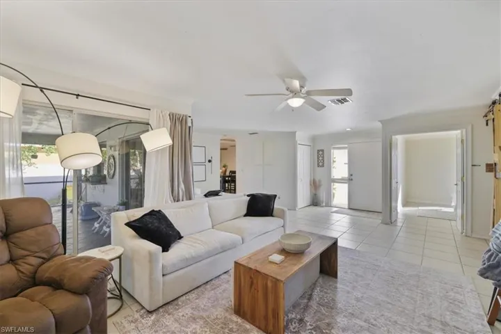 Living room featuring healthy amount of natural light, a ceiling fan, and light tile patterned floors