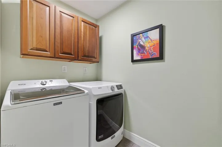 Laundry area featuring cabinets and washing machine and dryer