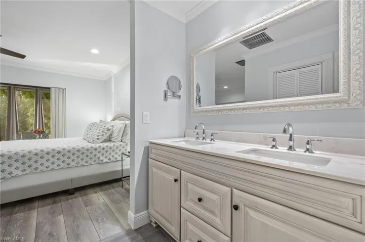 Bathroom featuring crown molding, hardwood / wood-style floors, and double vanity