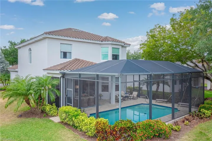 Back of house with a patio, a tile roof, an outdoor pool, a lanai, and stucco siding
