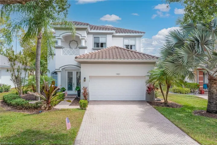 Mediterranean / spanish home with a front lawn, a garage, decorative driveway, a tiled roof, and stucco siding