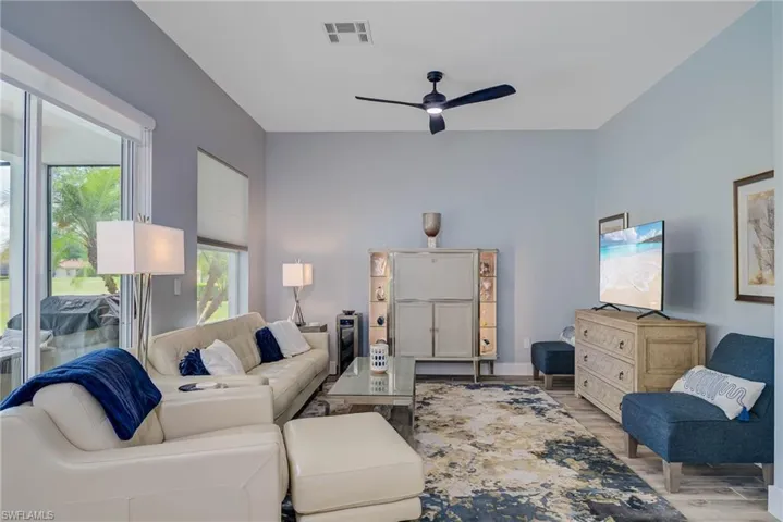 Living area with visible vents, wood finished floors, and a ceiling fan