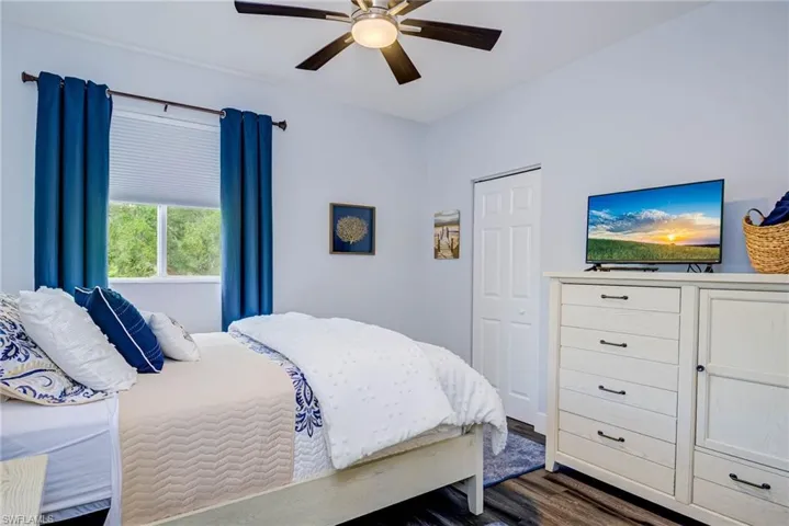 Bedroom with a ceiling fan and dark wood-style flooring
