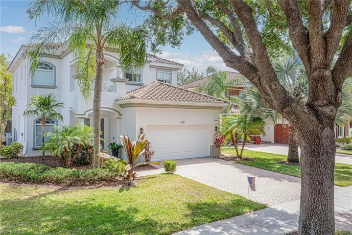 Mediterranean / spanish-style home featuring stucco siding, decorative driveway, a front lawn, and an attached garage