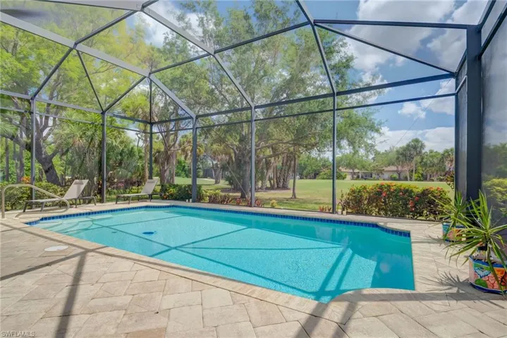 Pool with a patio and glass enclosure