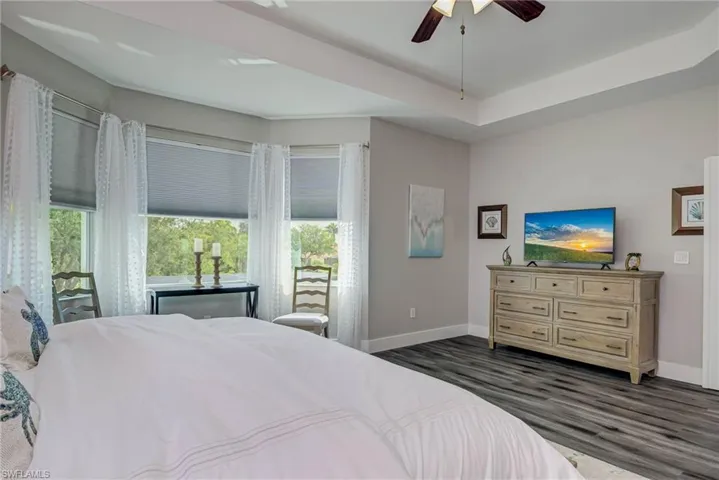Bedroom with dark wood-type flooring, a ceiling fan, and baseboards