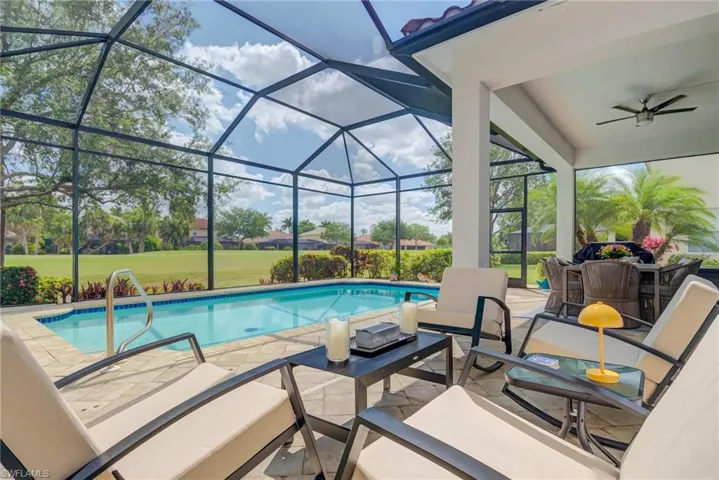 Outdoor pool with a patio, an outdoor hangout area, a lanai, a ceiling fan, and a lawn