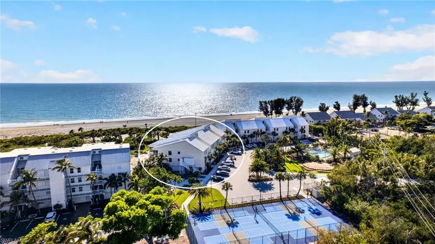 Beachfront property featuring multiple balconies, a coastal design, and a direct beach access path