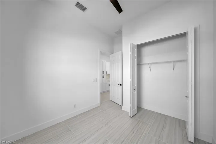 Unfurnished bedroom featuring a ceiling fan, a closet, baseboards, and visible vents