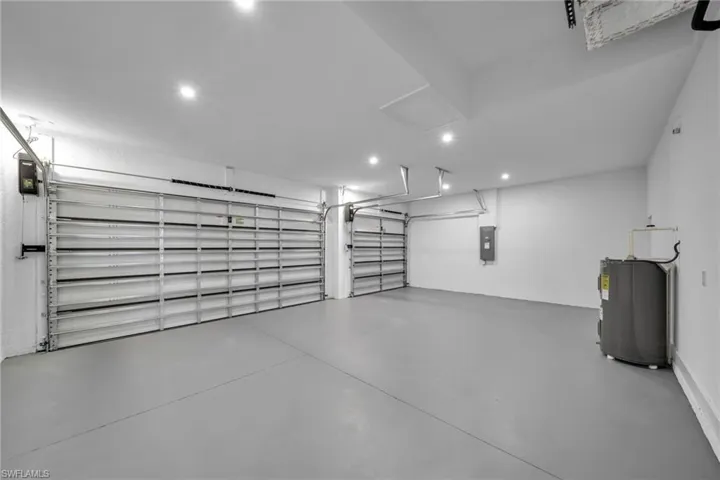 Garage featuring recessed lighting, electric water heater, and electric panel