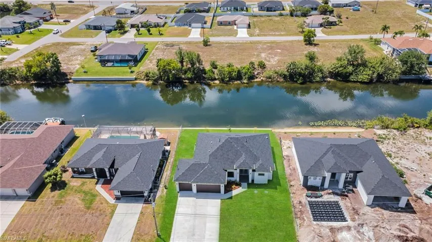 Birds eye view of property with a water view and a residential view