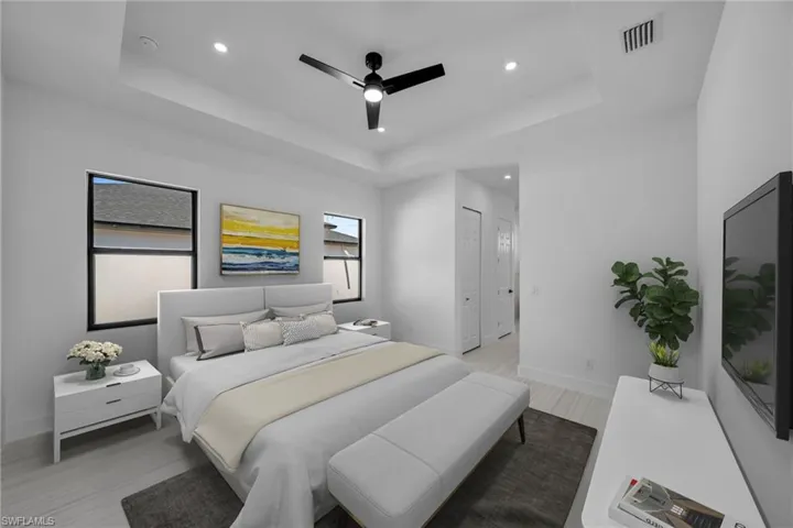 Bedroom featuring light wood-type flooring, a raised ceiling, recessed lighting, and visible vents