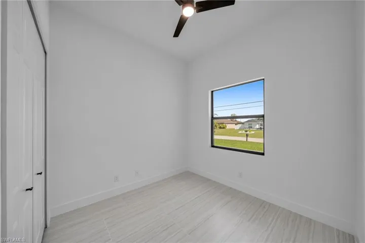 Empty room featuring baseboards and a ceiling fan