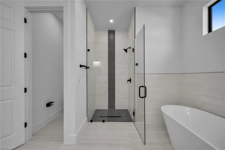 Bathroom featuring a shower stall, a soaking tub, and recessed lighting