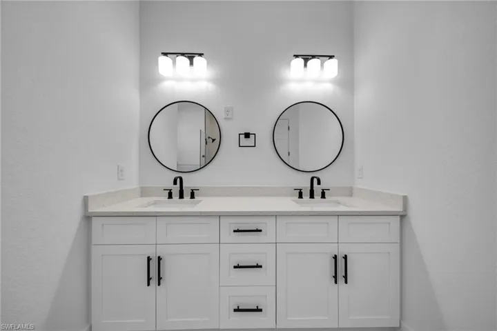 Bathroom with double vanity, baseboards, and a sink