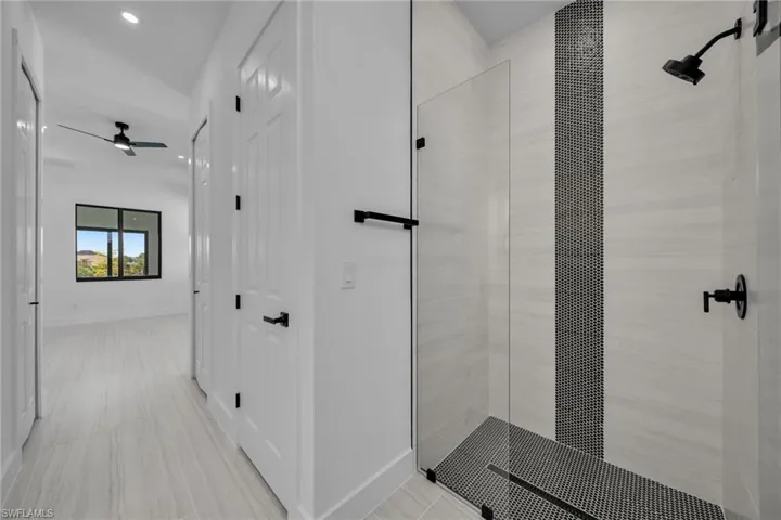Full bath with a stall shower, baseboards, recessed lighting, and a ceiling fan