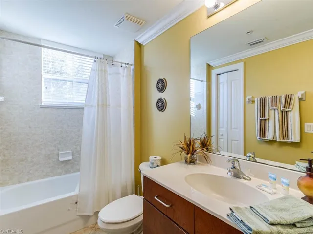 Full bath featuring ornamental molding, shower / bath combination with curtain, and vanity