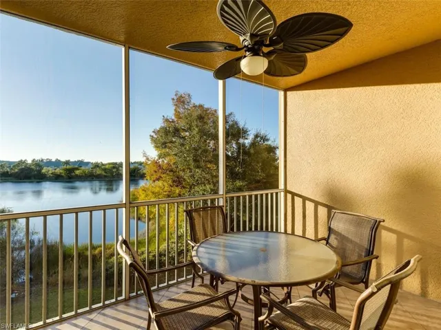 Balcony featuring a water view, a sunroom, and a ceiling fan