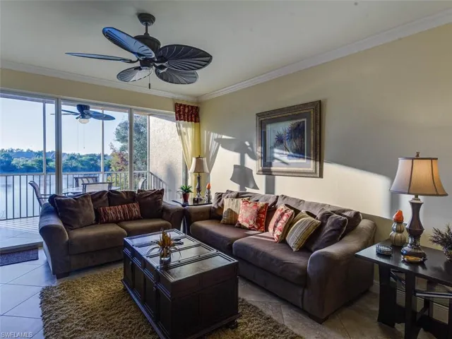 Tiled living room with crown molding, a water view, and ceiling fan