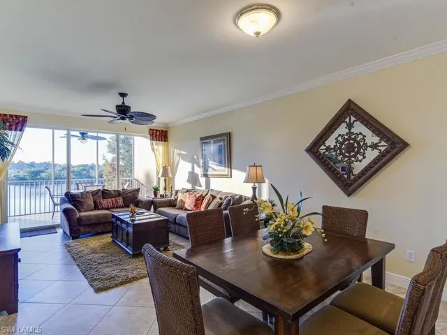 Dining space with ornamental molding, light tile patterned floors, a water view, and a ceiling fan