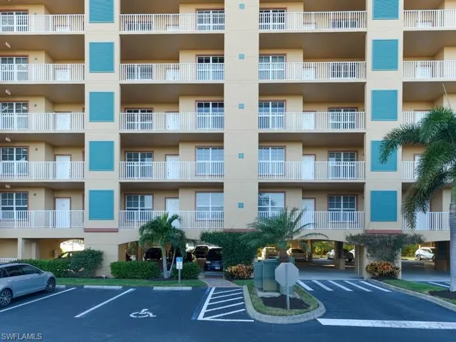 View of apartment building / complex featuring uncovered parking