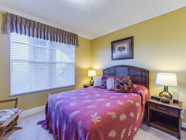 Carpeted bedroom featuring crown molding and baseboards